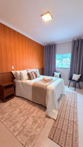 a bedroom with a large bed with a wooden wall at Suíte Ipê-Amarelo in Camanducaia