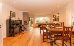 a dining room and living room with a table and a piano at Wattknistern in Garding