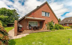 a brick house with a deck in the yard at Wattknistern in Garding