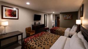 a hotel room with two beds and a television at Economy Inn in Las Cruces