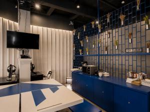a room with a blue counter with a tv on the wall at Loftel Station Hostel in Bangkok