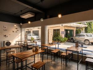 a restaurant with tables and chairs and a parking lot at Loftel Station Hostel in Bangkok