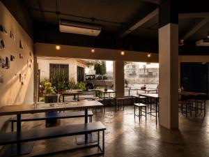 a room with tables and chairs in a building at Loftel Station Hostel in Bangkok