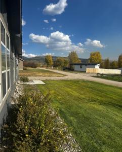 a yard with a house and a field of grass at 3 King Beds Spacious 4 BR 3 BATH AC Near Jackson in Victor