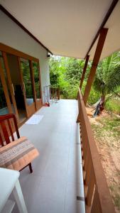 a porch of a house with a bench and windows at The Canal Hut Chaloklum in Chaloklum +7 photos