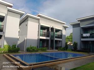 a building with a swimming pool in front of a building at Enap Machang in Macang