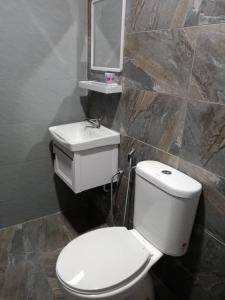 a bathroom with a white toilet and a sink at Enap Machang in Macang
