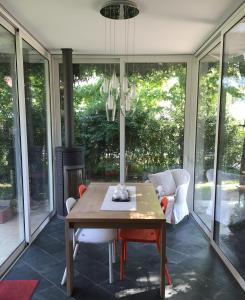 a screened in porch with a wooden table and chairs at La Mansarda di Margherita in Treviso