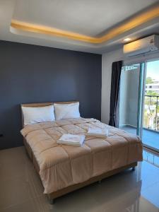 a large bed in a room with a large window at The wishes สมหวัง in Si Sa Ket