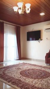 a bedroom with a large bed and a television on the wall at استراحة الروابي in Salalah