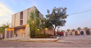 a building with a tree in front of it at The wishes สมหวัง in Si Sa Ket