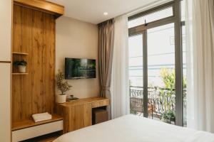 a bedroom with a bed and a large window at Minh An Villa in Da Thanh