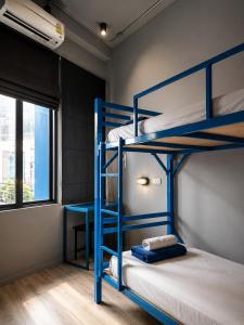 a bunk bed room with two bunk beds and a window at Loftel Station Hostel in Bangkok