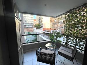 a balcony with a table and chairs and a large window at Del Pino Park in Buenos Aires