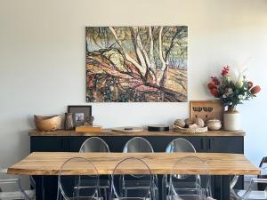 a dining room table with chairs and a painting on the wall at Jasper 3 in Jindabyne