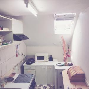 a small white kitchen with a microwave and a sink at Trapmouse hostel in Brussels +39 photos