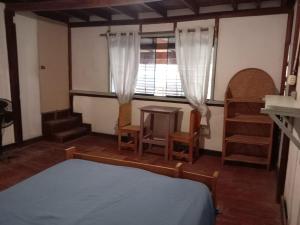 a bedroom with a bed and a table and a window at dondelachatahostel in Máncora
