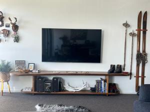 a living room with a television on a shelf at Jasper 3 in Jindabyne +32 photos