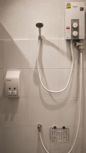 a shower hose hooked up to a wall in a bathroom at Loftel Station Hostel in Bangkok +57 photos