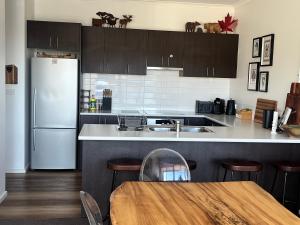 a kitchen with a table and a white refrigerator at Jasper 3 in Jindabyne
