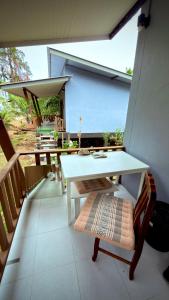 a white table and a bench on a balcony at The Canal Hut Chaloklum in Chaloklum