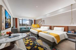 a hotel room with two beds and a table at Insail Hotels Guangzhou Beijing Road Pedestrian Branch in Guangzhou +80 photos