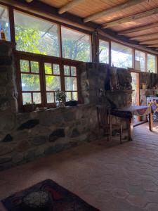 a room with a stone wall and a table and chairs at Refugio La Paciencia in Travesía