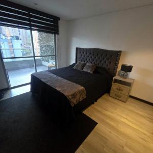 a bedroom with a large bed and a window at Apartamento terraza hamaca - doble parqueadero - Provenza in Medellín +9 photos