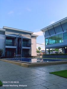 a large building with a swimming pool in front of it at Enap Machang in Macang
