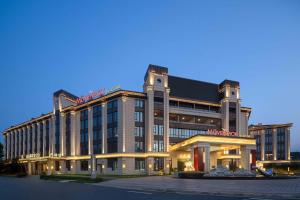 a hotel with a sign on the front of it at Mövenpick Kaifeng West Lake in Kaifeng