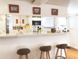 a bar with three stools in front of a counter at Cipango - Hong Kong Houseboat in Hong Kong