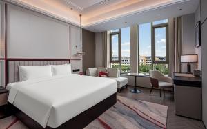 a bedroom with a large white bed and a large window at Mövenpick Kaifeng West Lake in Kaifeng +65 photos