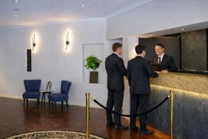 two men standing at a counter in a lobby at Crest on Barkly Hotel in Melbourne