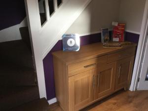 a room with a wooden dresser under a stairs at Constantine Court Homestay in Shepton Mallet