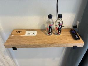 a wooden shelf with two bottles and a remote control at Private bedroom and bathroom in Rancho Santa Margarita +51 photos