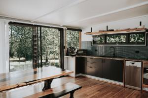 a kitchen with a table and a large window at The Artemis Cottage in Fitzroy