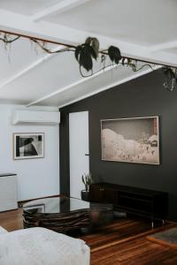 a dining room with a glass table and black walls at The Artemis Cottage in Fitzroy