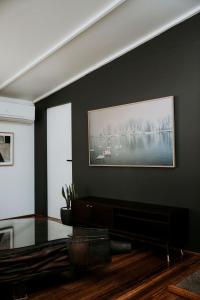 a living room with a table and a picture on the wall at The Artemis Cottage in Fitzroy