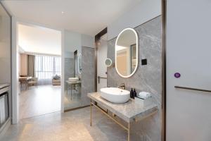 a bathroom with a sink and a mirror at Mercure Urumqi Doowin Wanda Plaza in Ürümqi