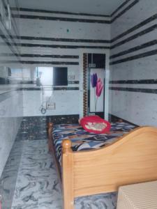 a bedroom with a bed with a red chair and a television at UP enterprices in Yercaud
