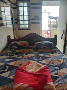 a bed with a red blanket on top of it at UP enterprices in Yercaud