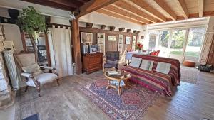 a living room with a bed and a table and chairs at L'humeur vagabonde in Linards
