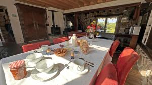 a dining room table with red chairs and a white table cloth at L'humeur vagabonde in Linards +19 photos