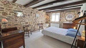 a bedroom with a bed and a table and chairs at L'humeur vagabonde in Linards