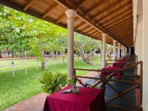 a table with a red table cloth on a porch at Happy Beach hotel nilaveli in Nilaveli