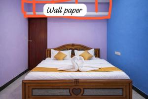 a bedroom with a bed with two towels on it at IP Home stays in Pondicherry