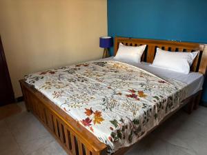 a bed with a comforter on it in a bedroom at IP Home stays in Pondicherry +2 photos