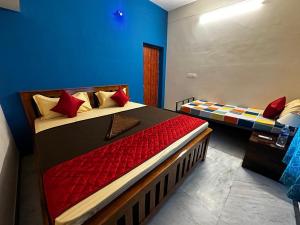 a bedroom with two beds with red pillows at IP Home stays in Pondicherry