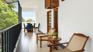 a balcony with chairs and a table and a dining room at Hasthi Boutique in Kandy