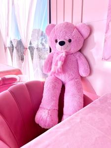 a pink teddy bear sitting on a couch at Pink Village Boutique in Campos do Jordão